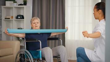 Sénior femme dans fauteuil roulant Faire réhabilitation traitement avec assistance de infirmière. entraînement, sport, récupération et levage, vieux la personne retraite maison, soins de santé allaitement, santé soutien, social assistance, médecin et Accueil un service photo