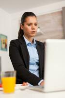 entrepreneur à la recherche à le plan de le journée avant le journée départs. concentré affaires femme dans le Matin multitâche dans le cuisine avant Aller à le bureau, stressant façon de vie, carrière et buts à rencontrer. photo