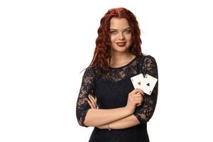 Jeune femme avec une longue rouge cheveux dans soir tenue, en portant en jouant cartes. isolé sur blanche. poker photo