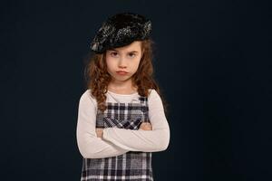 élégant brunette enfant est posant dans studio sur une noir Contexte. enfants mode. photo