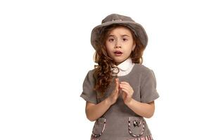 studio coup de une charmant peu enfant avec une long, frisé cheveux posant isolé sur blanc Contexte. photo