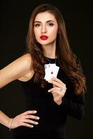 sexy frisé cheveux brunette posant avec deux as cartes dans sa mains, poker concept isolement sur blanc Contexte photo
