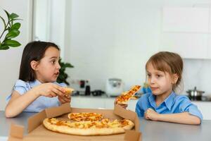 deux content peu enfant fille copains en mangeant Pizza tranches. photo