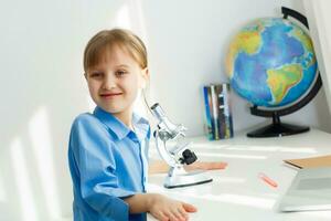 éloigné cours. le enfant sourit Heureusement et obtient connaissance à distance. peu fille étude en ligne apprentissage de maison. en ligne école. photo