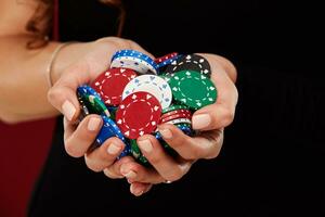 femelle poker joueur avec peindre blanc ongles tenir sa poker frites à faire une pari. jeux d'argent et casino affaires concept photo