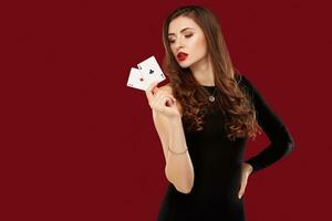 magnifique caucasien femme dans noir robe avec poker cartes jeux d'argent dans casino photo