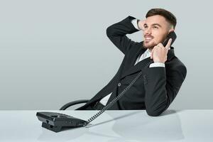 Jeune homme cadrans le téléphone nombre tandis que séance dans le Bureau photo