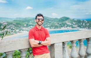 portrait de souriant touristique dans une point de vue de une baie. Beau touristique homme à la recherche à le baie de san Juan del sur photo