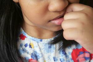 enfant fille mordant sa ongles à maison, photo