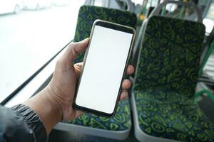 passager séance dans une autobus en utilisant le sien téléphone. photo