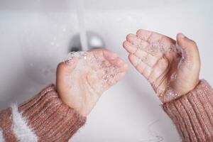 enfant se lavant les mains avec du savon photo