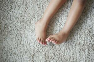 5 année vieux enfant fille pieds sur tapis Haut vue photo