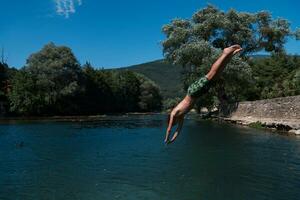 une homme dans une maillot de bain est sauter dans le l'eau photo