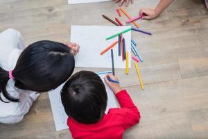 groupe d'élèves d'âge préscolaire et d'enseignants dessinant sur papier en classe d'art. retour à l'école et concept d'éducation. thème des personnes et des modes de vie. chambre en crèche photo