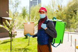 livraison homme envoyer nourriture sac à porte bouton pour sans contact ou contact gratuit de livraison cavalier dans de face maison pour social distanciation pour infection risque. photo