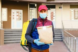 sans contact nourriture livraison à les clients maison. livraison un service ouvrier avec thermique sac à dos rapide livrer nourriture à seuil de porte dans quarantaine de restaurant, supermarché ou café . en ligne commande nourriture photo