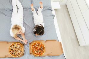 mère et fille en mangeant Pizza. relaxant à Accueil photo