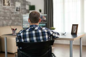 vidéo éditeur dans fauteuil roulant travail sur film Publier production. invalide vidéaste Faire le sien affaires en ligne, en utilisant haute technologie, séance dans le sien appartement, travail à distance dans spécial conditions. photo