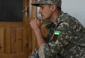 ukrainien soldat portant militaire uniforme avec drapeau et chevron représentant trident - ukrainien nationale symbole drapeau photo