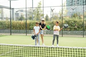 actif Jeune femme pratiquant padel tennis avec groupe de joueurs dans le tennis tribunal en plein air photo