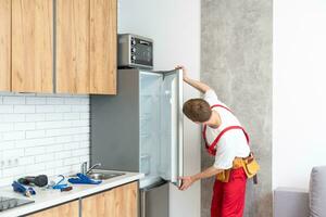 électricien technicien travail à réparation réfrigérateur ou frigo appareil photo