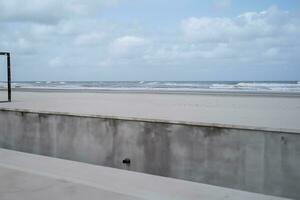 les pièces de béton bâtiment à le plage de le mer ai génératif photo