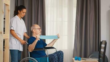 Sénior homme avec invalidité dans fauteuil roulant Faire récupération exercice avec thérapeute. désactivée handicapé vieux la personne avec social ouvrier dans récupération soutien thérapie physiothérapie soins de santé système allaitement retraite Accueil photo