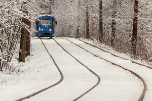 un vieux tramway se déplaçant dans une forêt d'hiver photo