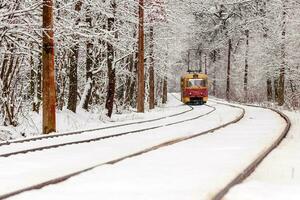 un vieux tramway se déplaçant dans une forêt d'hiver photo