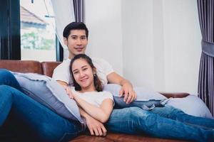 jeunes couples asiatiques se détendre sur le canapé. concept d'amoureux et de couples. lune de miel et thème de mariage. thème de l'intérieur et des rencontres