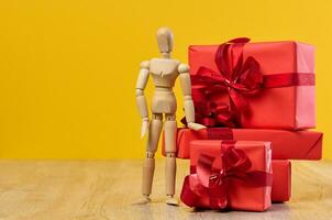 empiler de cadeaux et en bois mannequin sur Jaune Contexte photo