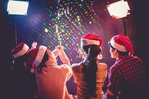 vue arrière des jeunes asiatiques qui célèbrent noël et le nouvel an. concept de vacances et de bonheur. thème de l'amitié et de la détente photo