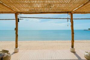 en bois terrasse avec toit boho style sur le plage dans tropical mer photo