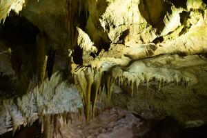 le la grotte est le karst, incroyable vue de stalactites et stalagnites illuminé par brillant lumière, une magnifique Naturel attraction dans une touristique lieu. photo