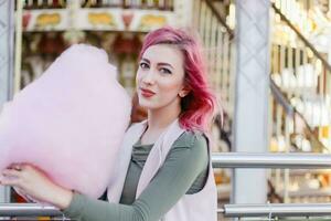 rose cheveux fille court la Coupe de cheveux posant dans amusement parc sur carrousel Contexte. photo