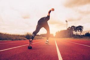 coucher de soleil et jeune homme qui court sur la voie. succès et objectif du concept d'entreprise. thème sportif et exercice photo