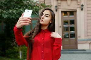 portrait de Jeune attrayant femelle dans élégant tenue fabrication selfie photo