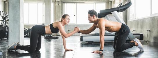 couple aime les jeunes hommes et les femmes de remise en forme s'exercent ensemble. concept de programme de musculation et de cardio. photo