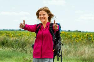 femme promeneur montrant les pouces en haut dans le la nature photo