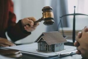 concept de justice et de droit. juge masculin dans une salle d'audience avec le marteau, travaillant avec, clavier d'ordinateur et d'accueil, lunettes, sur table à la lumière du matin photo