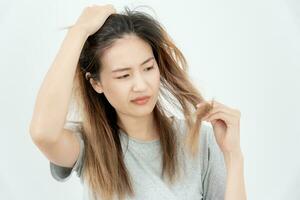 asiatique femme très triste et dérangé à la recherche à endommagé cheveux, cheveux perte, cheveux éclaircie problème, vitamine carence, calvitie, post-partum, biotine, zinc, menstruel ou endocrine troubles, hormonale déséquilibre photo