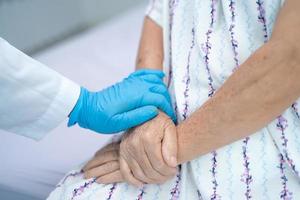 médecin tenant des mains touchantes femme âgée ou vieille dame asiatique patiente avec amour, soins, aide, encouragement et empathie à l'hôpital de soins infirmiers, concept médical fort et sain photo