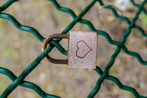 une cadenas sur une vert chaîne lien clôture photo