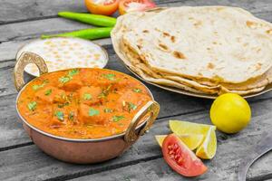 Indien délicieux cuisine paneer tikka Masala avec tandoori chapati sur en bois Contexte photo