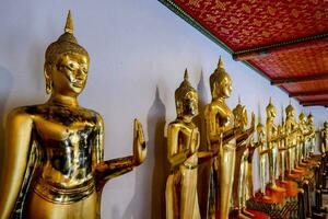 une rangée de d'or bouddhas dans une temple photo