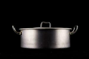 une métal pot sur une noir Contexte photo