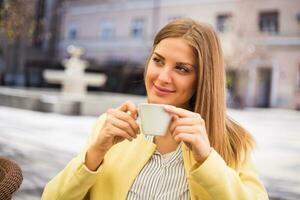 magnifique Jeune femme jouit en buvant café à le ville. photo