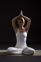 femme exercice yoga intérieur sur noir arrière-plan, photo