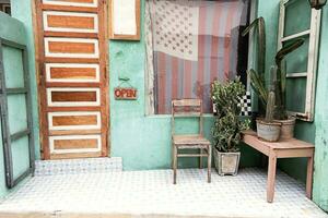 vieux chaise et cactus près de face porte de petit ancien pays magasin. photo