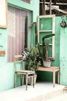 vieux chaise et cactus près de face porte de petit ancien pays magasin. photo